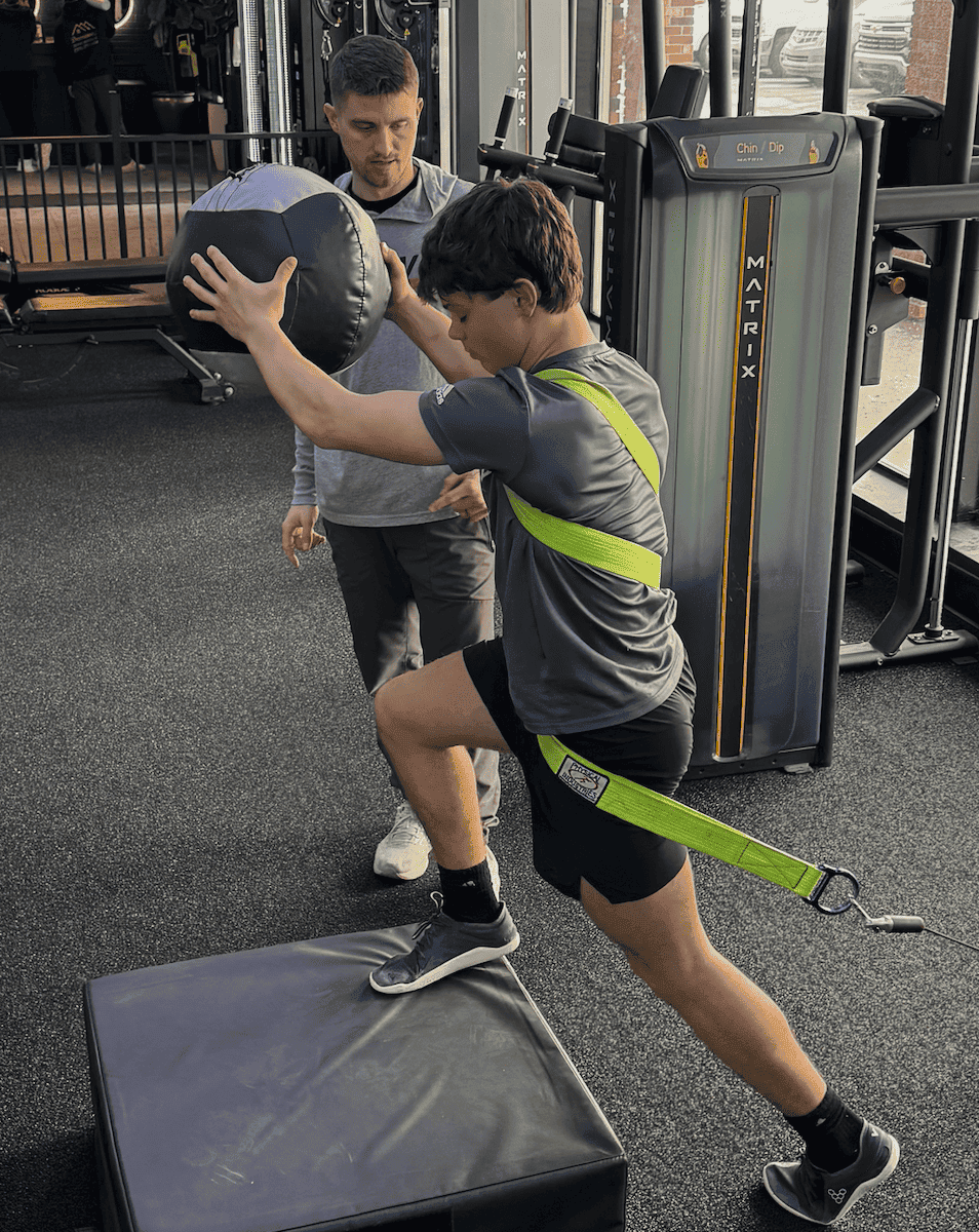 Athlete doing ACL rehab exercises with sports physical therapist in clinic